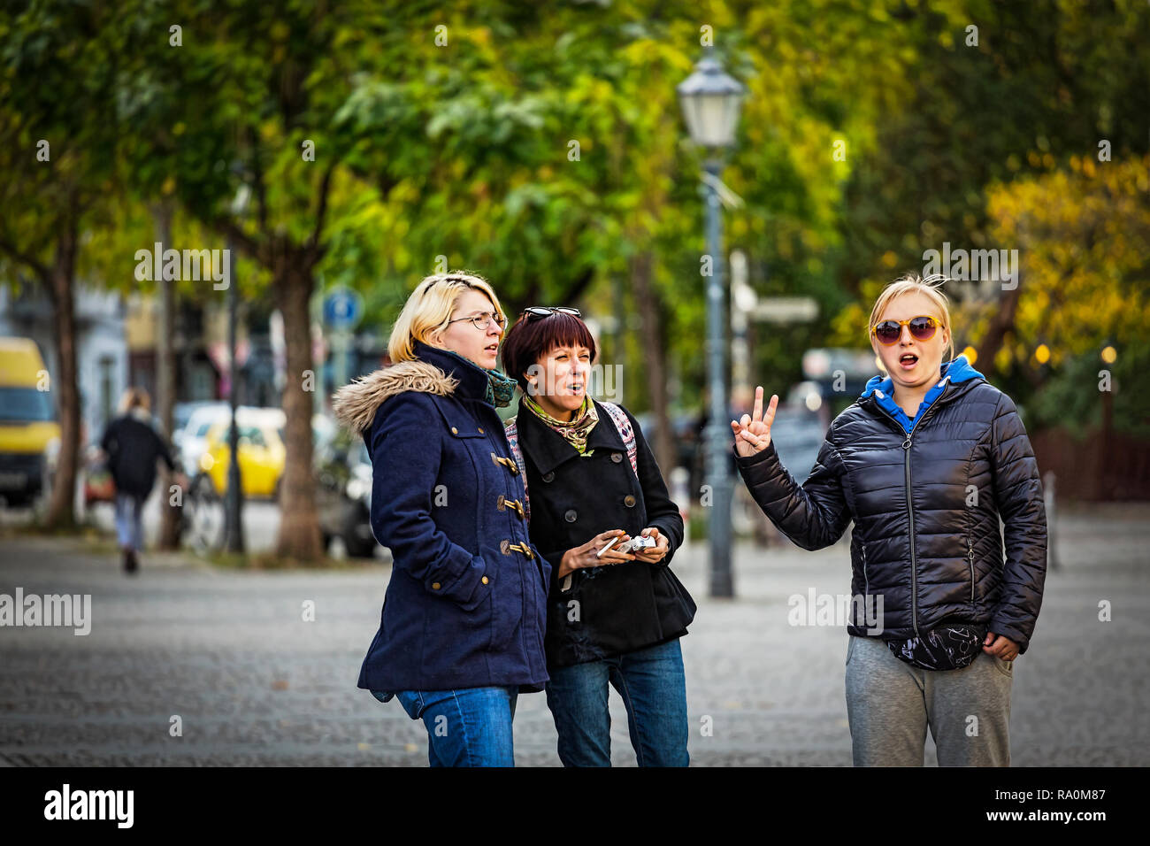 Azienda amici ragazze su una passeggiata in una città europea moderna Foto Stock