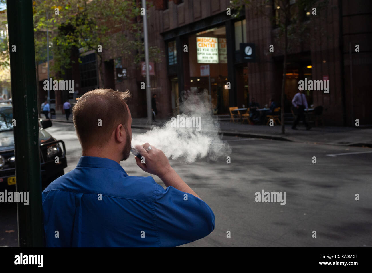 10.05.2018, Sydney, Nuovo Galles del Sud, Australien - Ein Mann raucht auf einer Strasse im Geschaeftsviertel von Sydney eine elektrische Zigarette / E-Zig Foto Stock