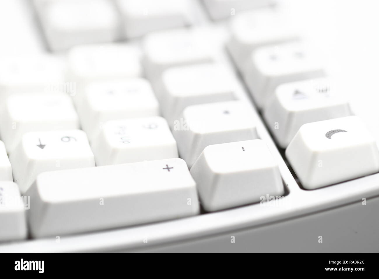 Moderna tastiera per computer. Parte della tastiera bianca per computer con messa a fuoco ridotta, focalizzazione su '+ -' Foto Stock