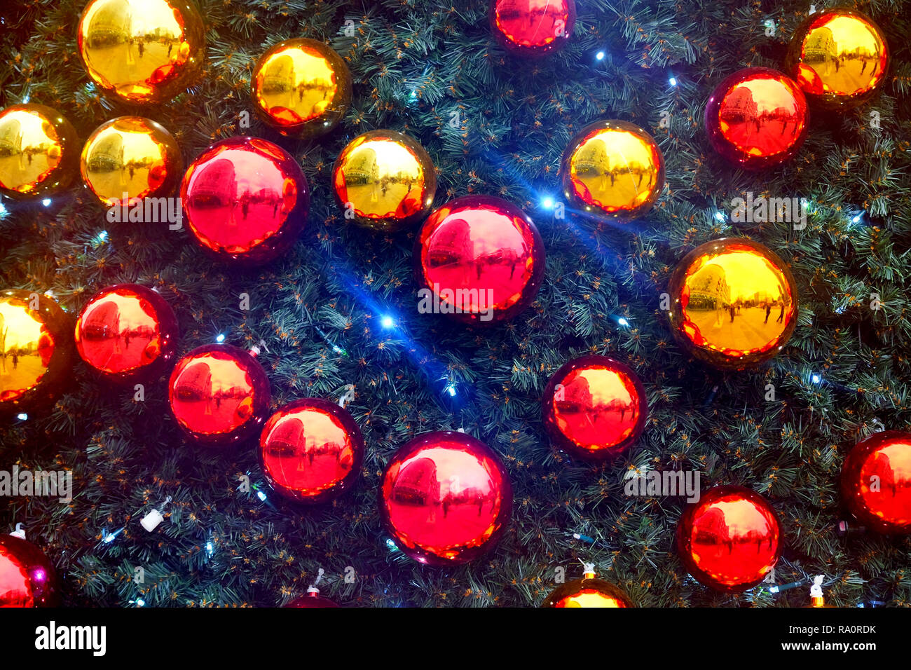 Luminose e chiny rosso e oro baubles di natale su una pelliccia di pino albero di natale Foto Stock
