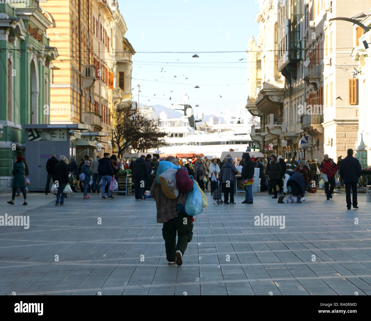 Rijeka, Croazia, Dicembre 29, 2018. Una città di mercato pieno di gente e di uomo con sacchi sul suo retro Foto Stock