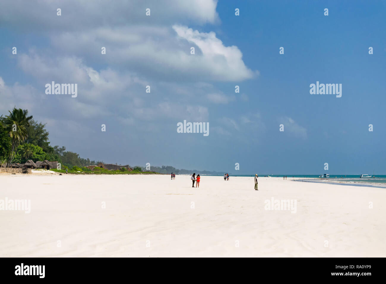 La gente del posto e i turisti sulla tropicale di sabbia bianca spiaggia di Diani in inizio di mattina di sole, Diani, Kenya Foto Stock