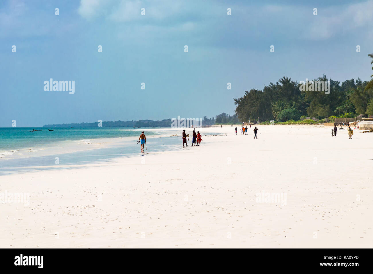 La gente del posto e i turisti sulla tropicale di sabbia bianca spiaggia di Diani in inizio di mattina di sole, Diani, Kenya Foto Stock