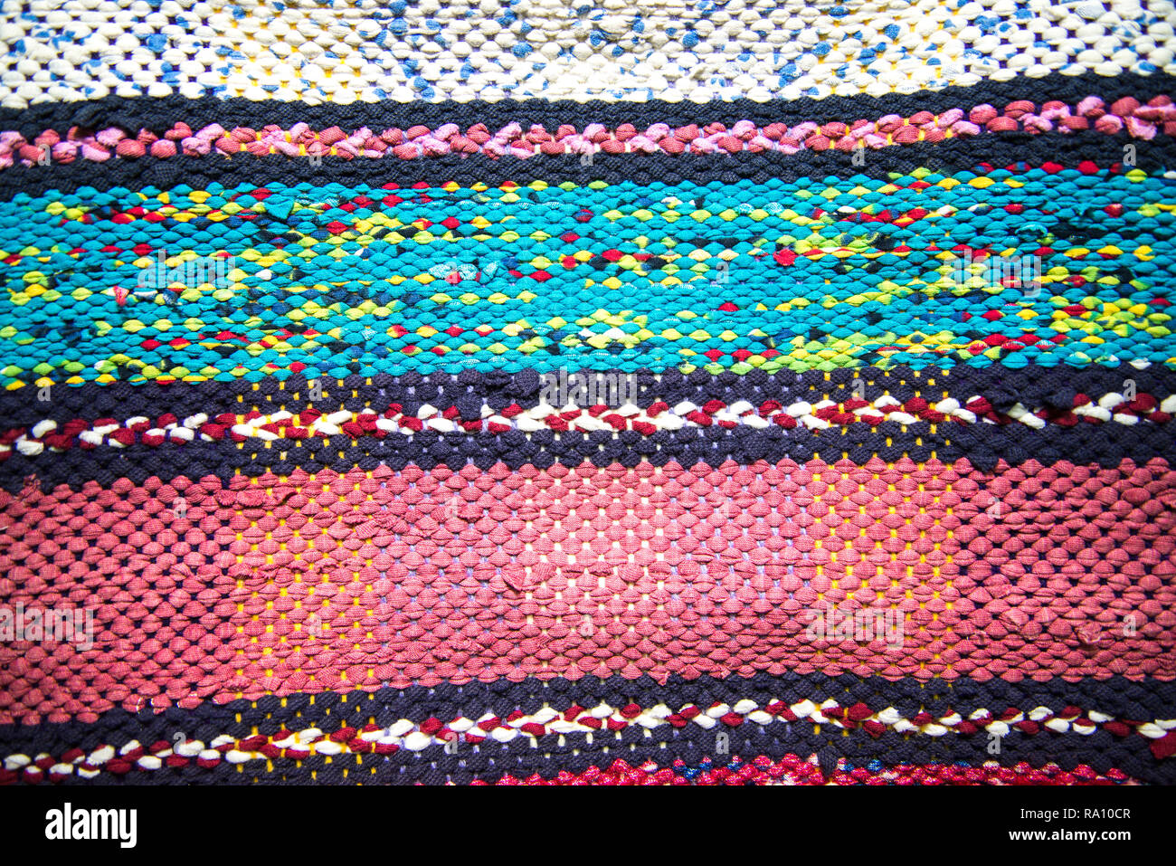 Texture di multi-colore di homespun rug. In stile rustico tradizionale molto lungo tappeto con un pattern a strisce per l'uso su un banco o sul pavimento Foto Stock