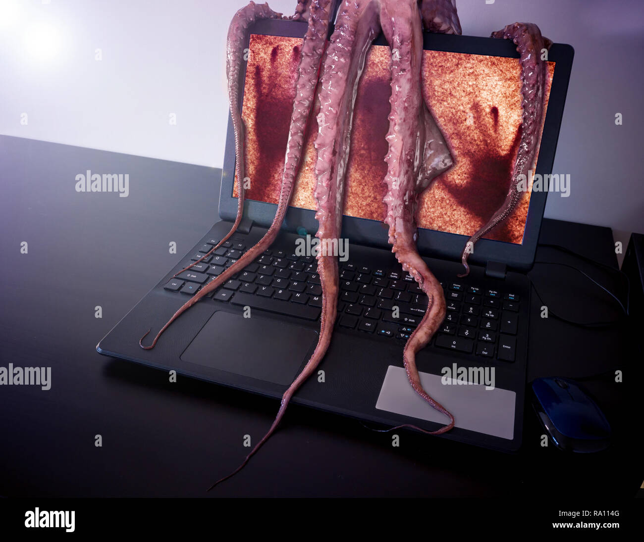 Computer virus concetto. Notebook con uomo dentro sequestrato da disgustoso mostro con lunghi tentacoli appiccicosi. Foto Stock