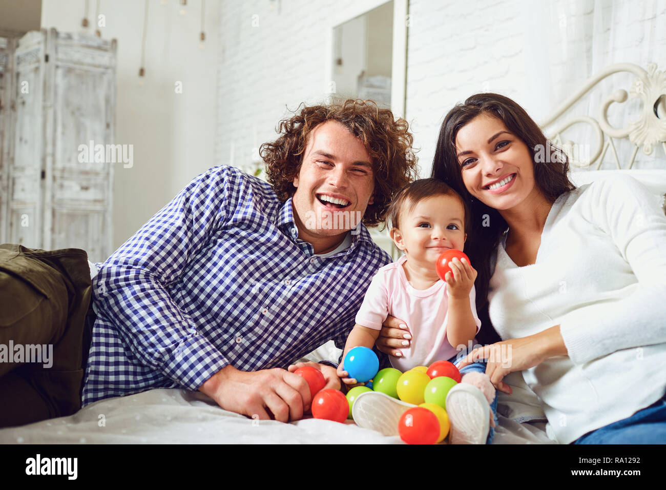 La famiglia felice con un bambino mentre è seduto in una stanza. Foto Stock