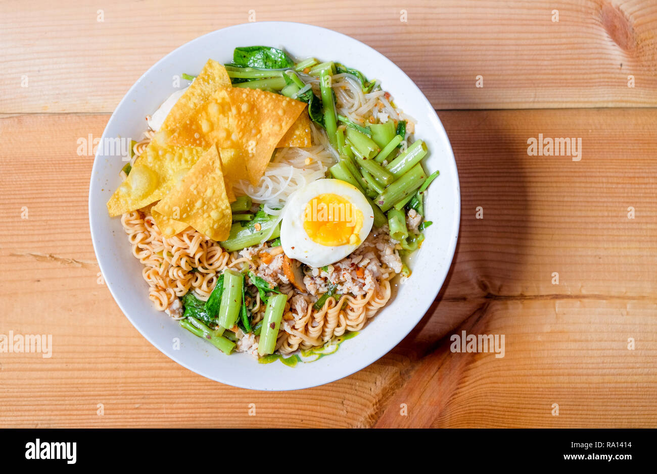 Tom Yum tagliatelle speciali di mettere una piccola linea, tagliatelle istante, convolvulus, uovo sodo e gnocco in una ciotola di pasta bianca su legno chamcha, sulla vista superiore Foto Stock