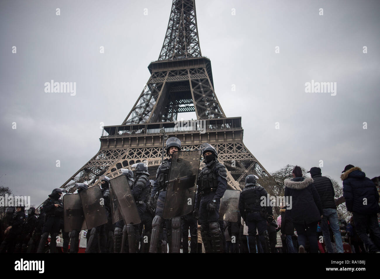 La polizia antisommossa è visto alla Torre Eiffel durante la protesta. Giubbotto giallo i manifestanti si sono riuniti e hanno marciato per le strade di Parigi un altro sabato in quello che chiamano l'atto VII contro il presidente francese Emmanuel Macron's politiche. Foto Stock