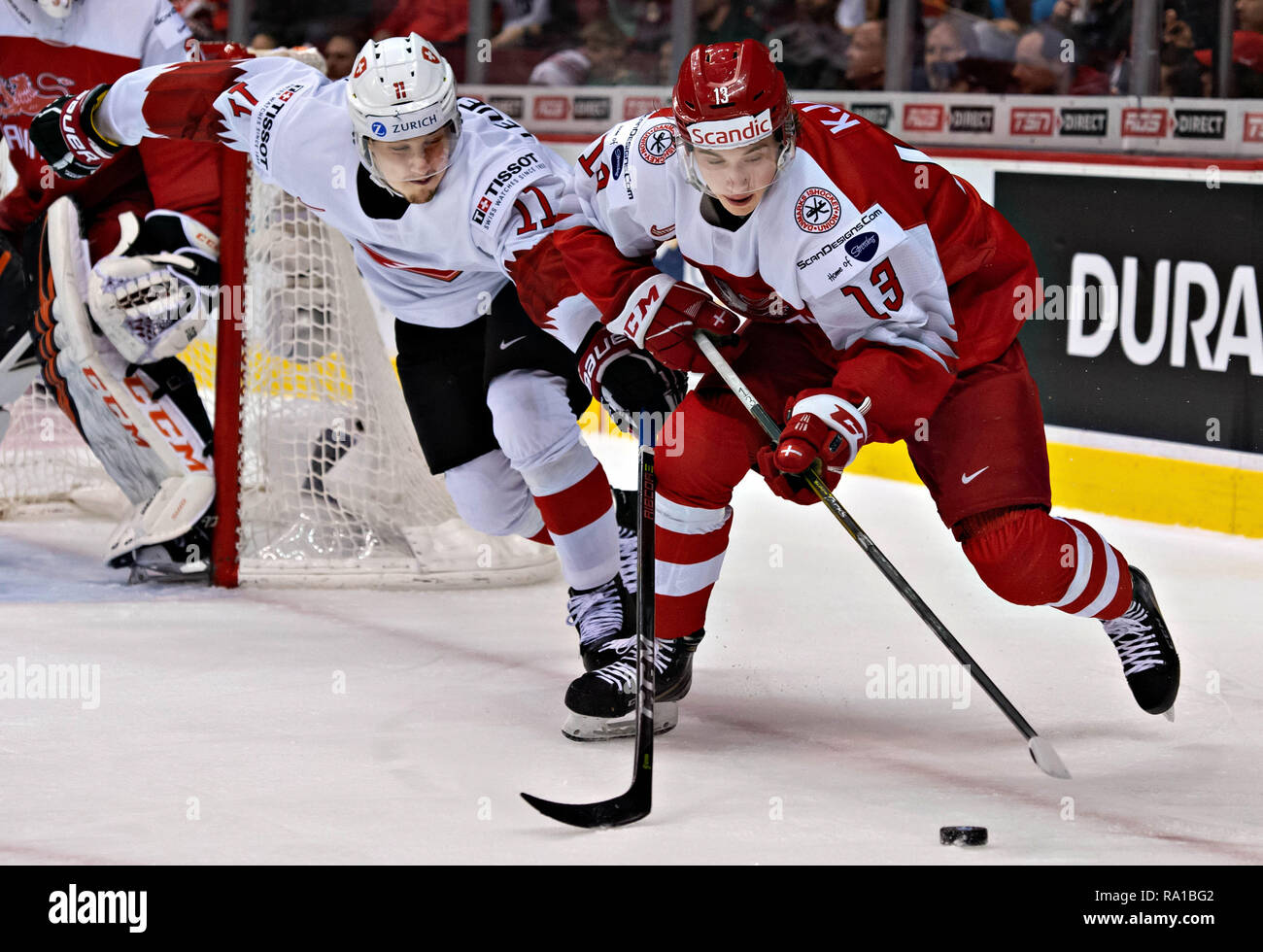 Vancouver, Canada. . 29 Dic, 2018. Svizzera di Sven Luenberger (L) e la Danimarca Oliver Kajer competere durante la IIHF Junior World Championships in Vancouver, Dic 29, 2018. La Svizzera ha vinto la partita preliminare 4-0. Credito: Andrew Soong/Xinhua/Alamy Live News Foto Stock