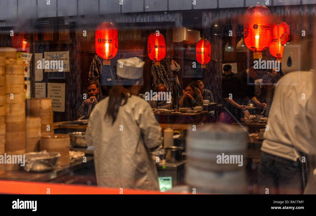I clienti presso un ristorante cinese ai loro tavoli, Chinatown, Londra, Inghilterra, Regno Unito. Foto Stock
