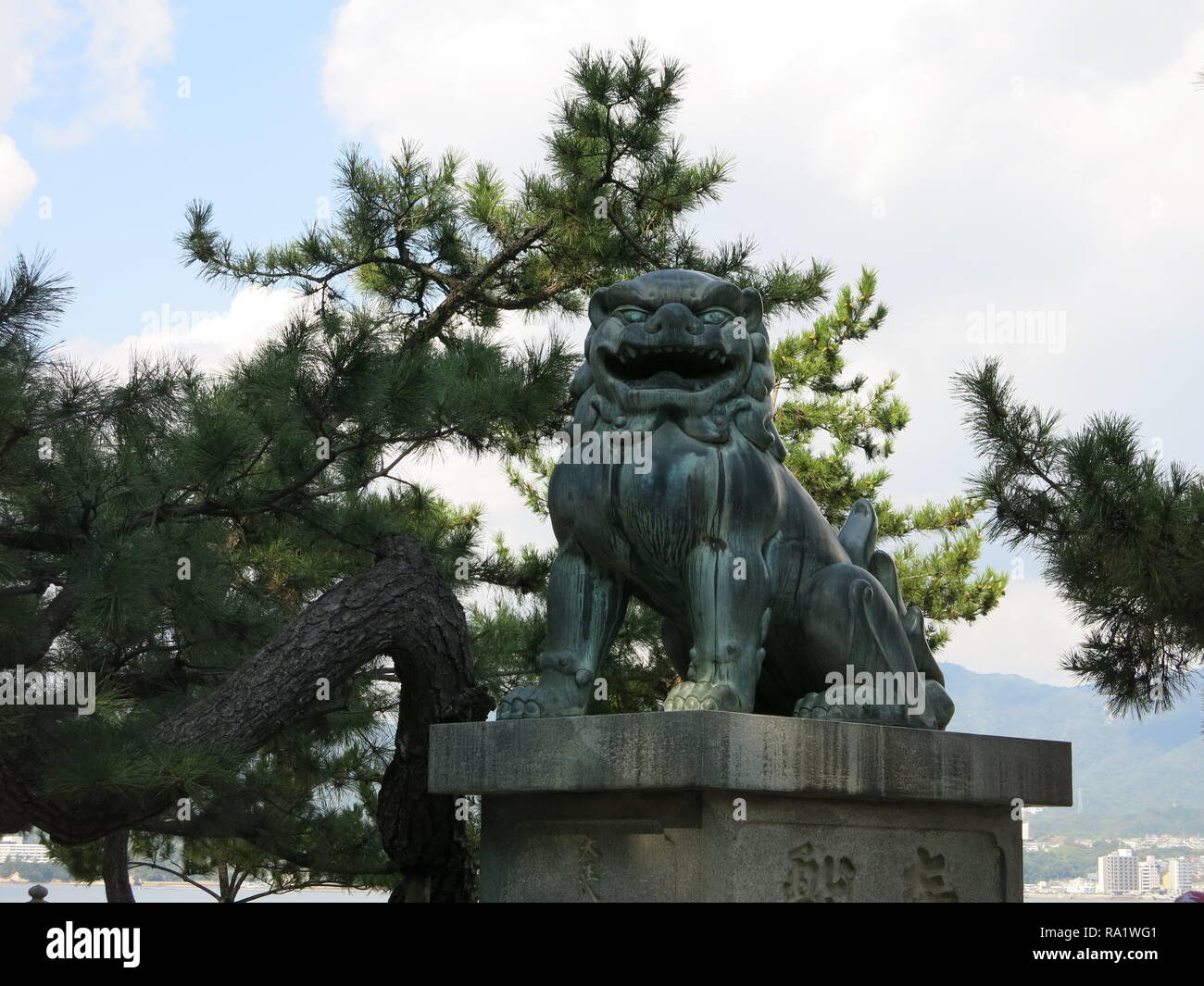 Close-up della bocca aperta lion (agyoo), uno della coppia di statue custodendo l'entrata al santuario di Itsukushima, l'isola di Miyajima, Giappone Foto Stock
