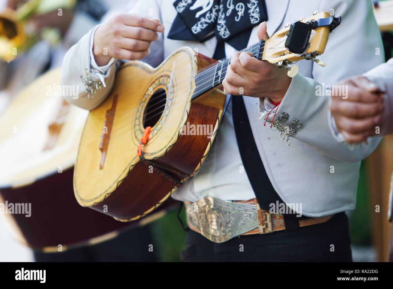 Mariachi messicani con il bianco costumi tradizionali la riproduzione della vihuela a una festa Foto Stock