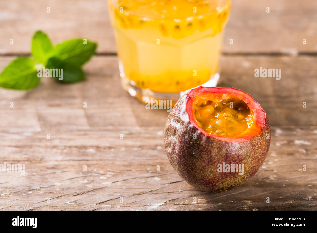 Bicchiere di freschi frutti della passione con la menta sul tavolo Foto Stock