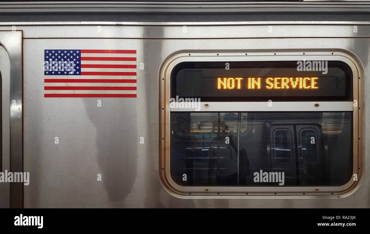 Cartello con la dicitura non in servizio sulla metropolitana di New York Auto con finestra e bandiera americana Foto Stock