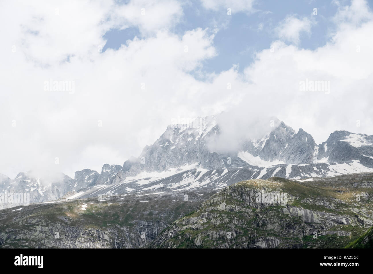 Picco di montagna ricoperta di neve e dalle nubi Foto Stock