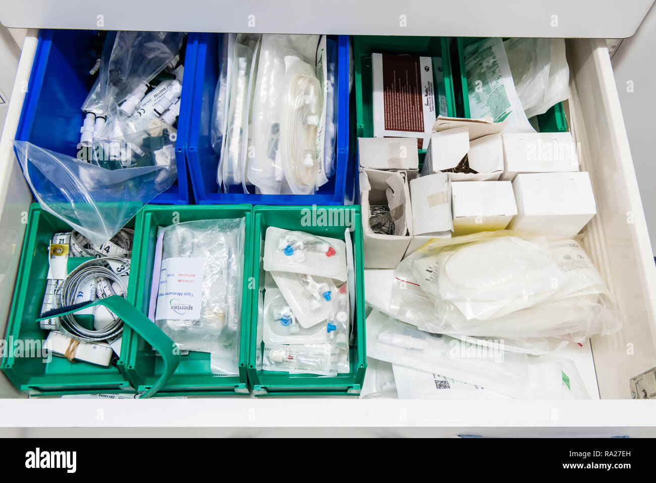 Cassetto in un ospedale sala di trattamento contenenti attrezzature come dando imposta, cannule, tamponi, e misure a nastro Foto Stock