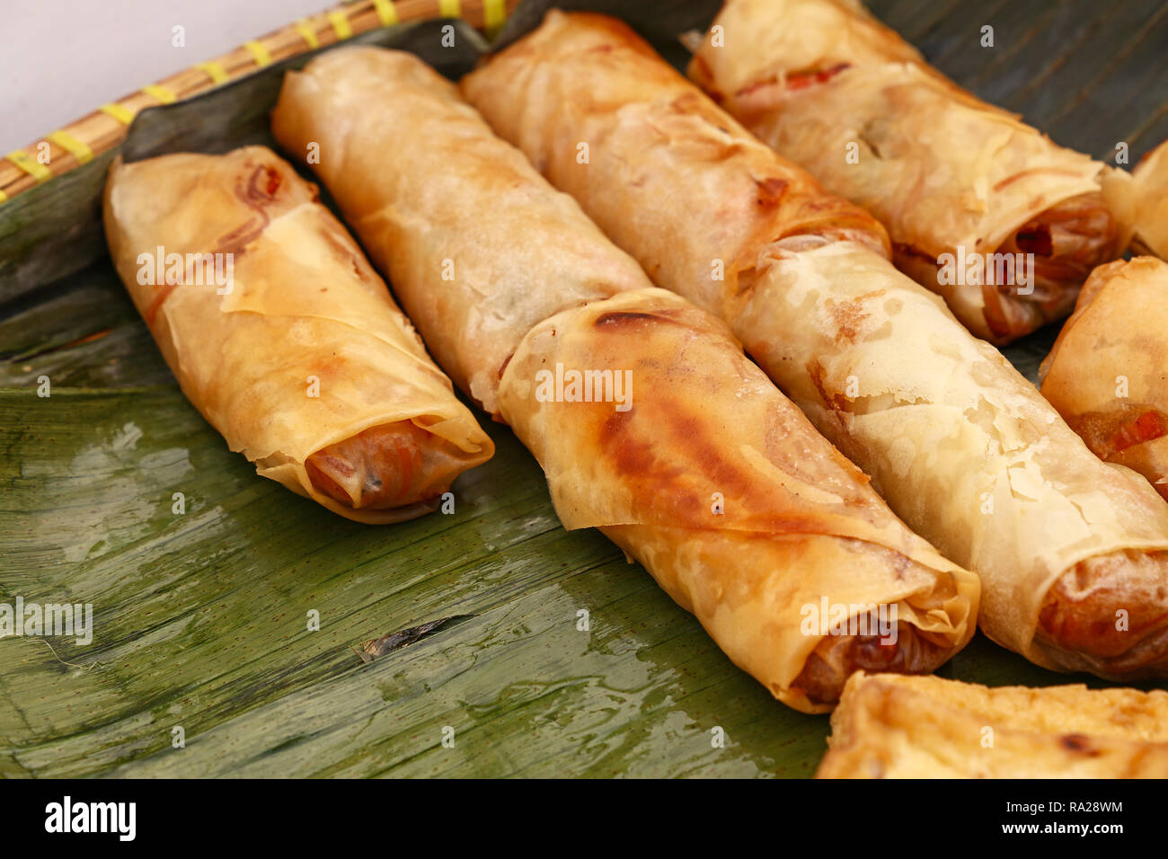 Porzione di diversi fritti croccanti involtini primavera, tradizionale cucina Asiatica antipasto spuntino servito su Verde foglie di banano, ad alto angolo di visione Foto Stock