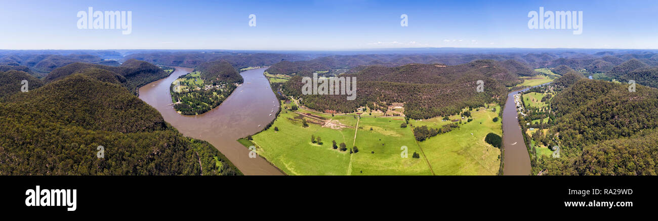 Wisemans Ferry città sulle rive del fiume Hawkesbury al entrayce di Macdonald fiume in un ampia valle verde tra le gamme della montagna nella foto da abov Foto Stock