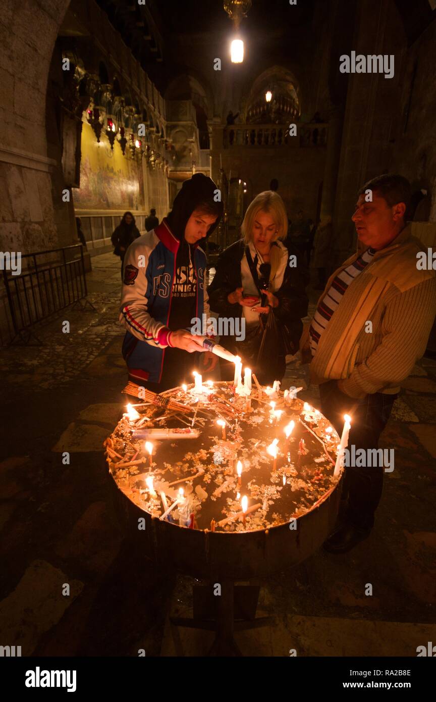 Pellegrini russi accendono le candele nella chiesa del Santo Sepolcro di Gerusalemme Foto Stock