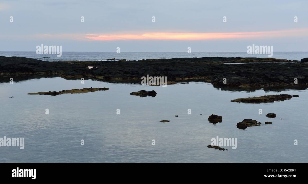Tramonto sulla spiaggia di Pu'uhonua o Honaunau il luogo di rifugio di Big Island delle Hawaii Foto Stock