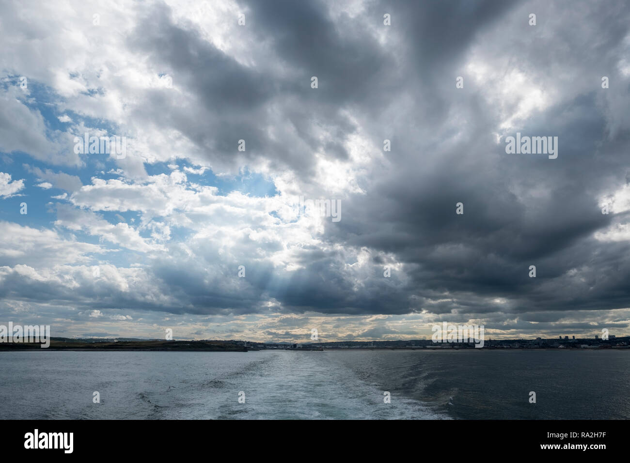 Riattivazione di un traghetto per auto come si lascia il porto di Aberdeen, Scozia su un brillantemente nuvoloso giorno al crepuscolo Foto Stock