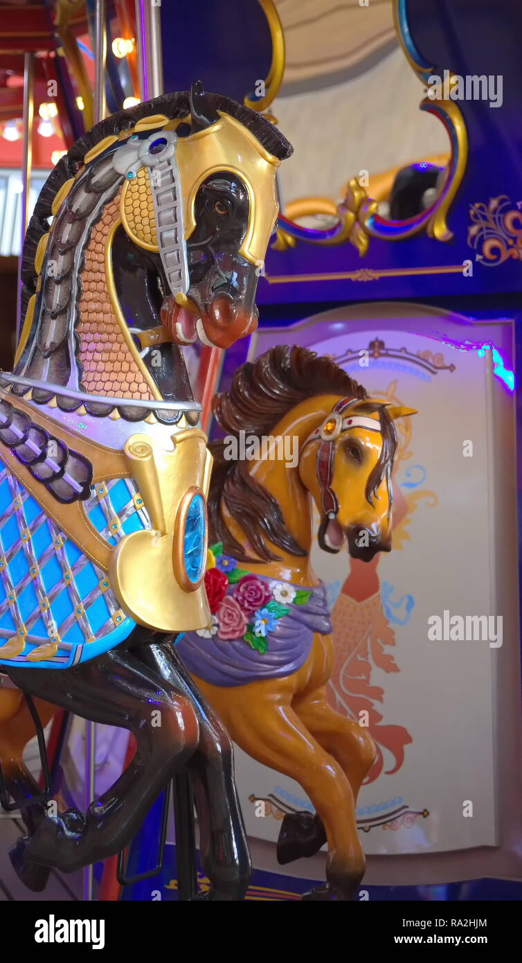 Un dipinto e coloratissima giostra cavallo in un parco di divertimenti Foto Stock