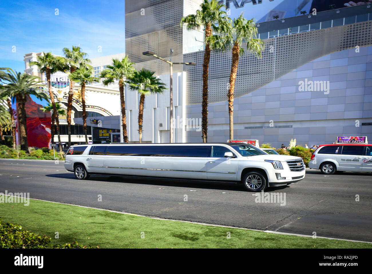 Una limousine bianca Cadillac Stretch viaggiando sulla Las Vegas Strip, fiancheggiata da palme, di fronte al LINQ Hotel and Casino di Las Vegas, NV, in una giornata di sole Foto Stock