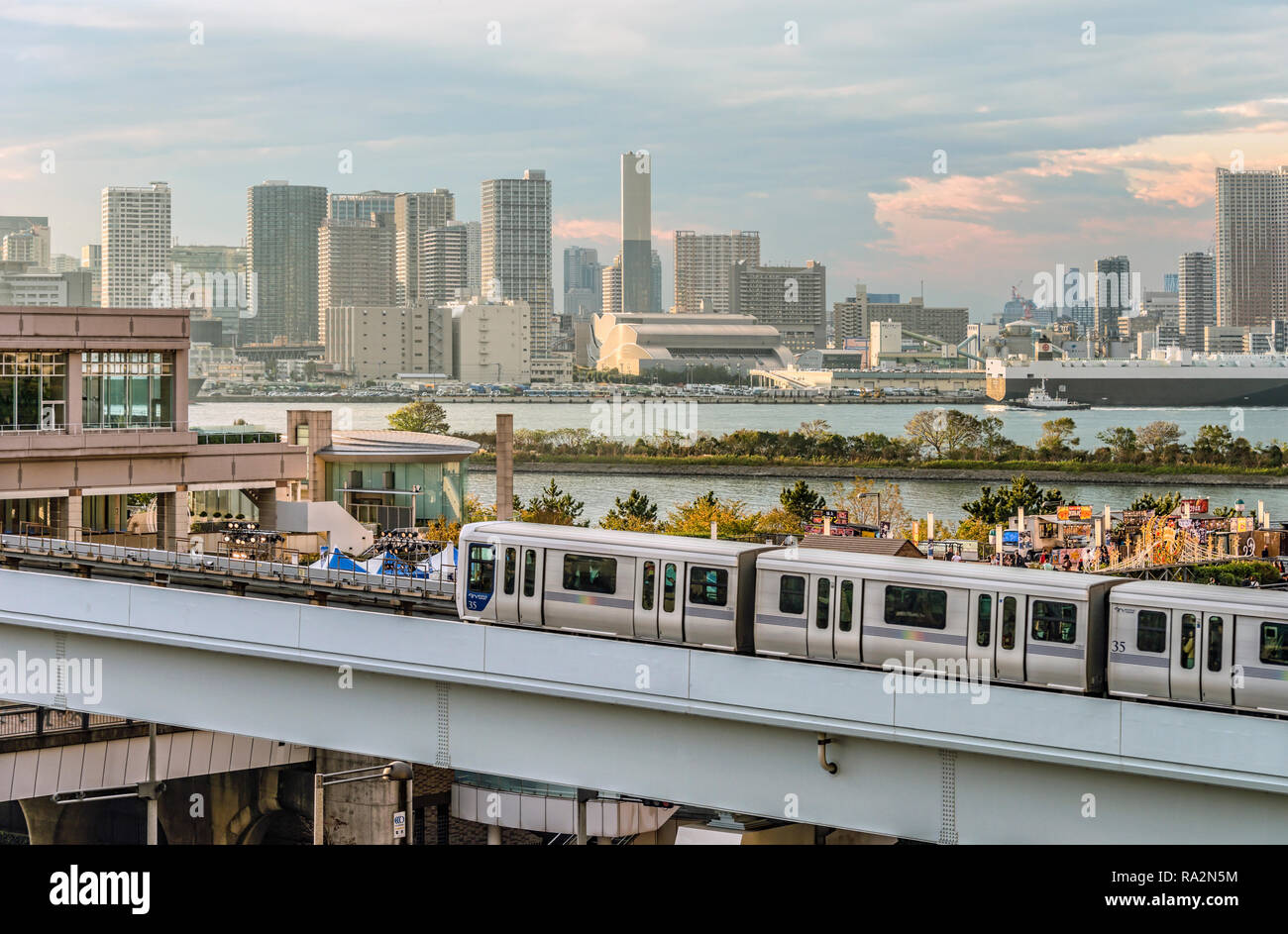 Tokyo Yurikamome treno monorotaia a Odaiba con lo Skyline di Tokyo sullo sfondo, Giappone Foto Stock