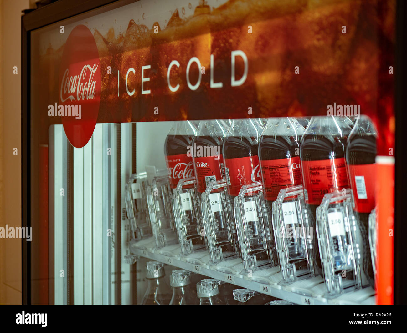 Coca Cola ghiaccio logo freddo riempiti con bottiglie all'interno di un distributore automatico Foto Stock