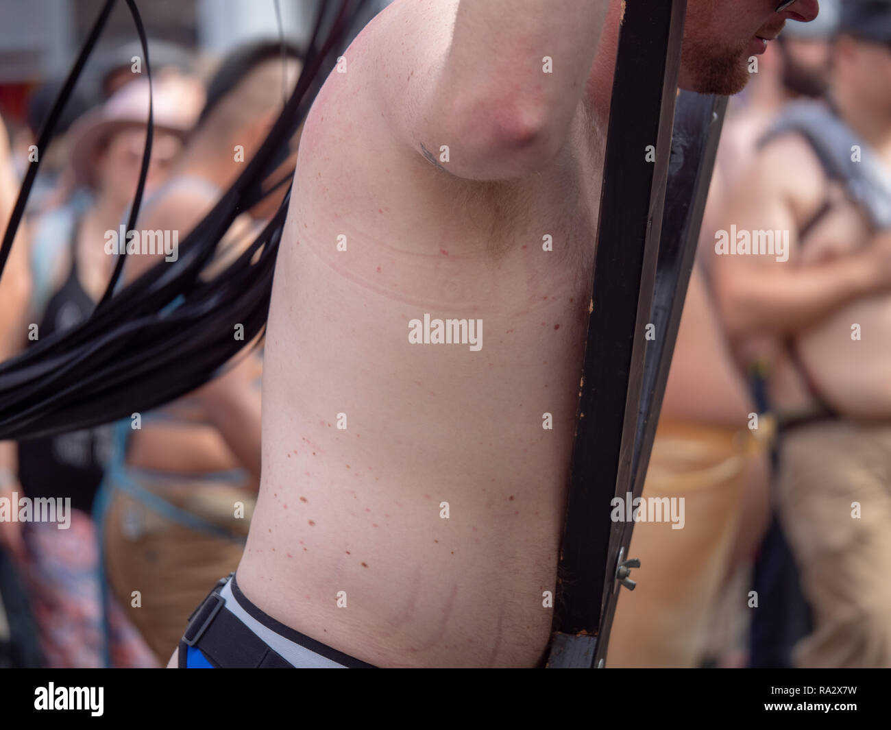 L'uomo legato in BDSM apparato ottenere frustato da nero frustino in pelle  Foto stock - Alamy