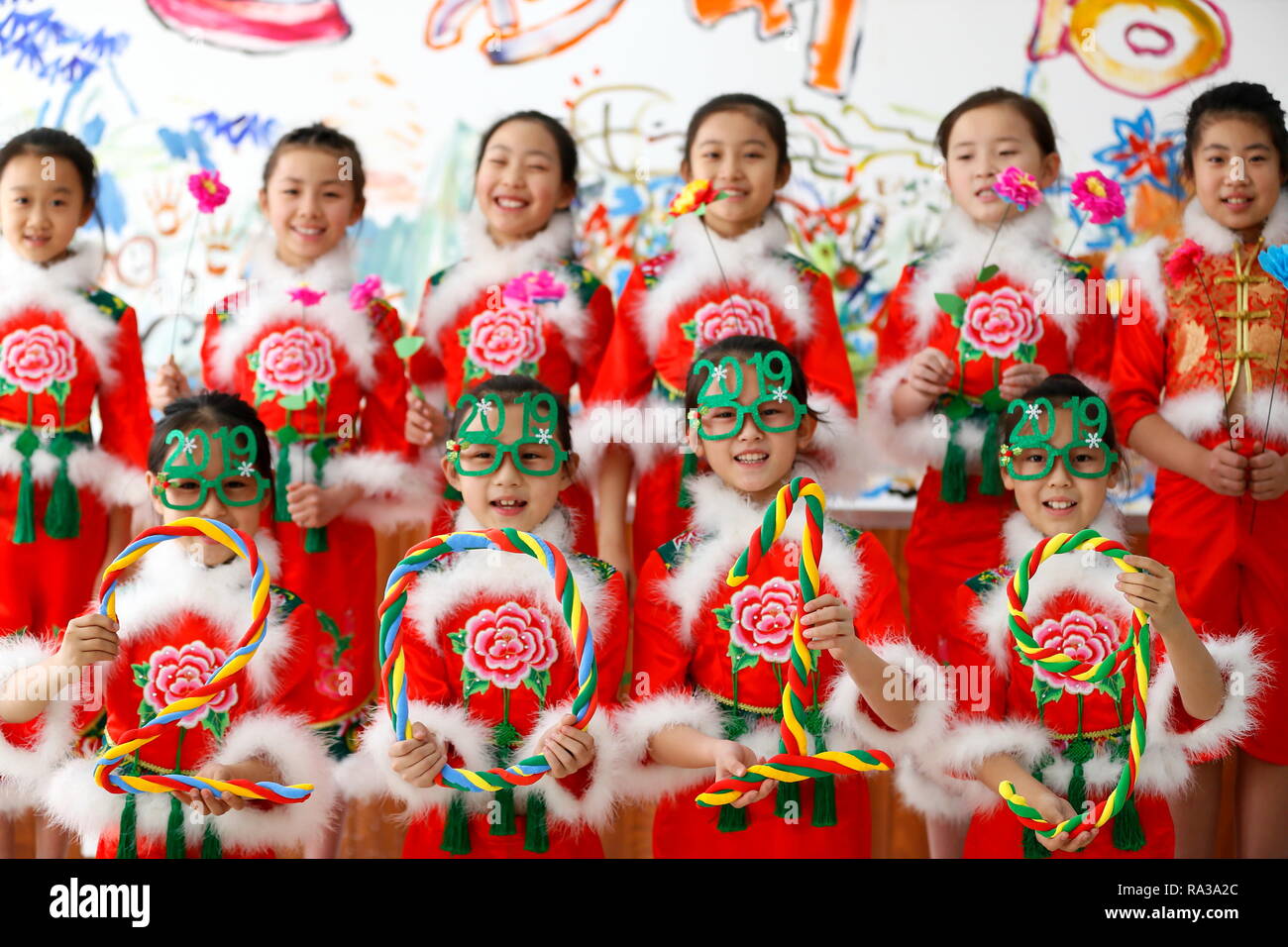 Qingdao, Cina Shandong. 1a gen, 2019. Gli alunni vestiti in costumi di festa posano per una foto di gruppo a Qingdao, Cina orientale della provincia di Shandong, 1 gennaio, 2019. Le varie attività sono state organizzate in tutta la Cina per salutare l'anno di 2019. Credito: Liang Xiaopeng/Xinhua/Alamy Live News Foto Stock