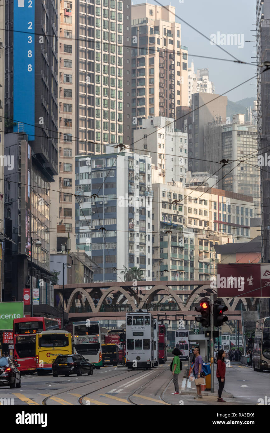 Edifici impilate una sull'altra quasi sopraffare le persone a livello di strada in uno di Hong Kong è più affollato di distretti. Foto Stock