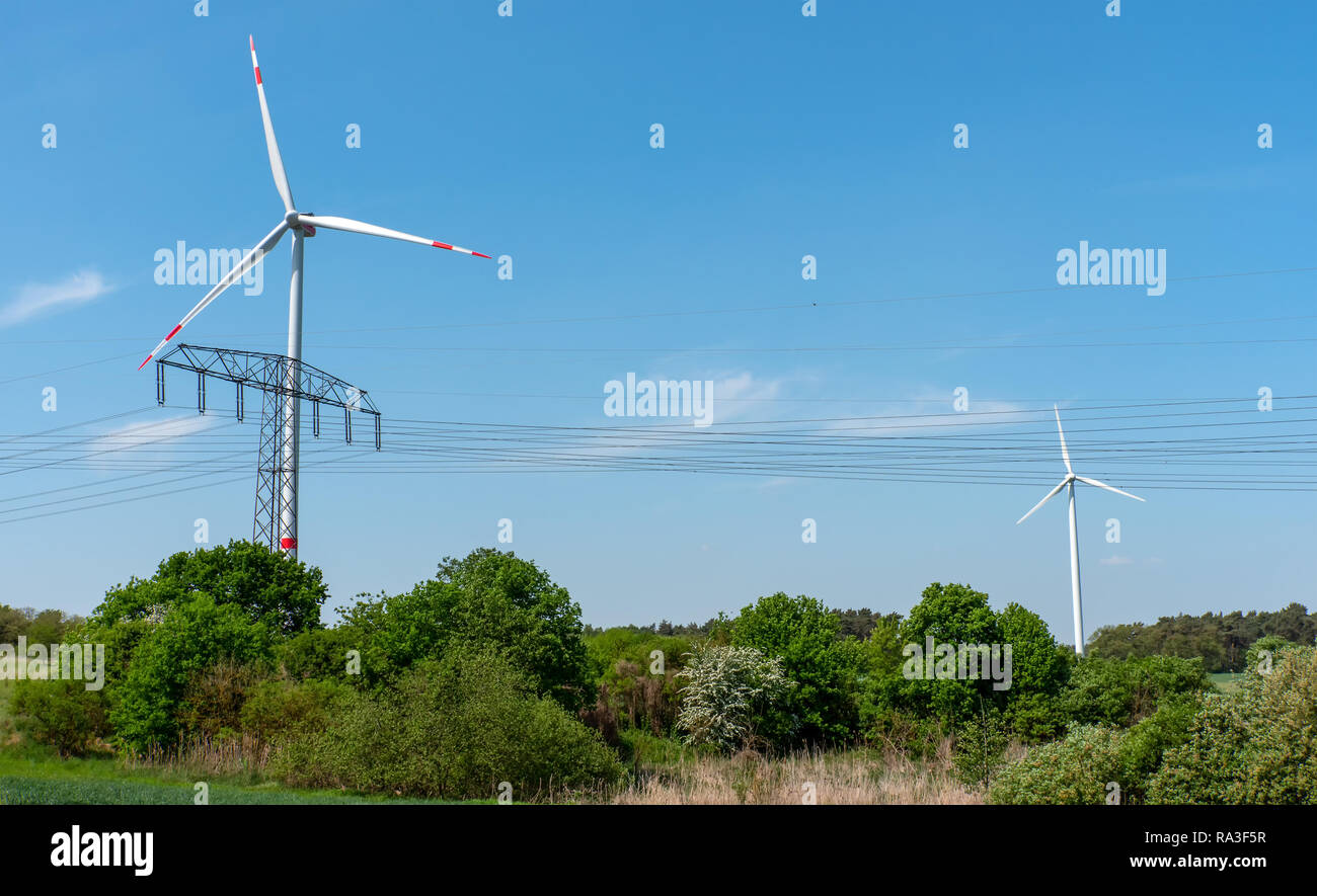 Le turbine eoliche, linee aeree e la macchia visibile in Germania Foto Stock