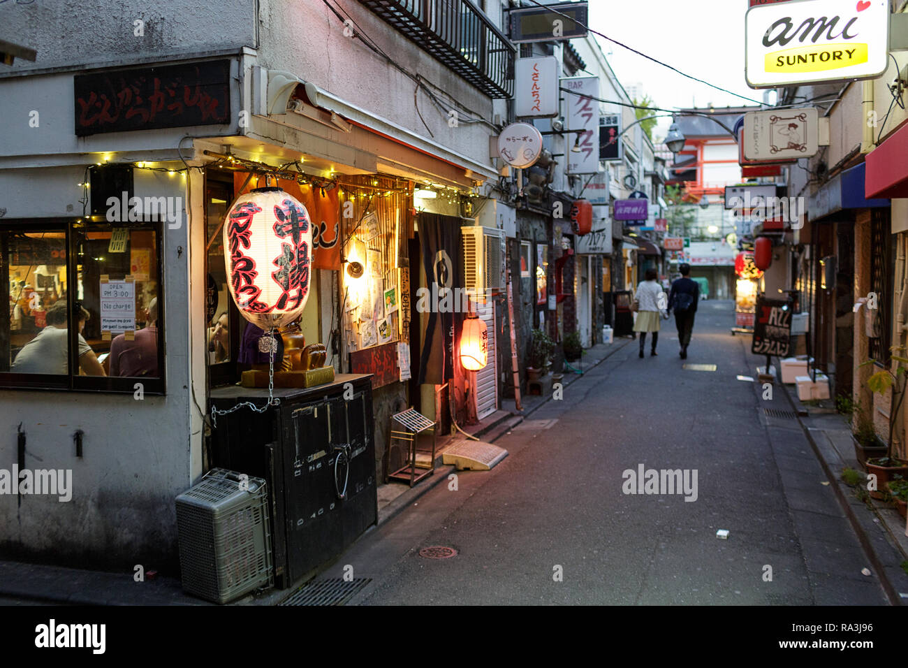 Giovane tenendo le mani mentre si cammina da Tokyo tradizionale street ristoranti. Giappone Foto Stock