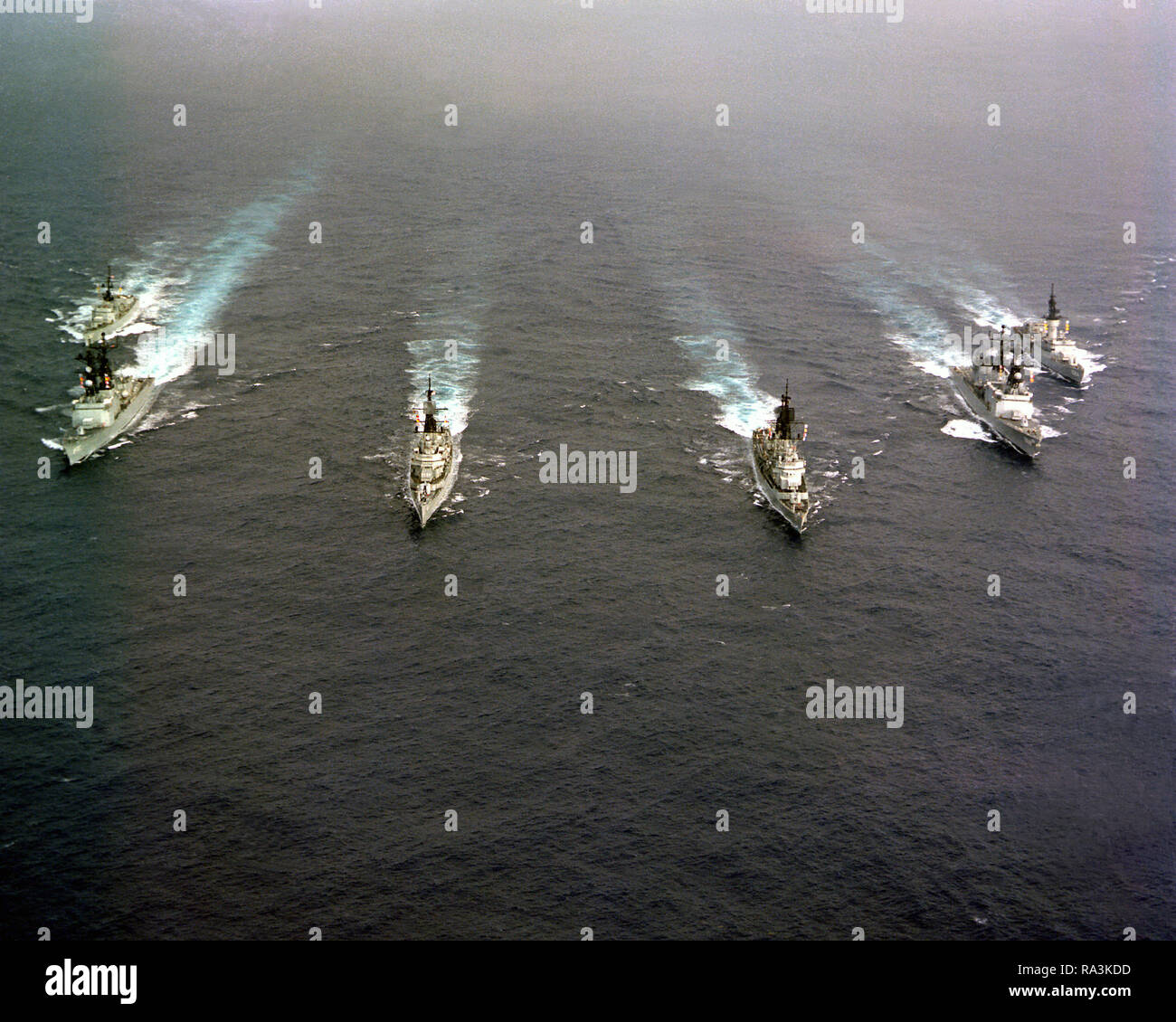 1979 - un elevato vista di prua di sei navi nell'USS INDIPENDENZA (CV-62) gruppo di combattimento come loro capo home dalla distribuzione nel Mar Mediterraneo. Le navi sono, da sinistra a destra, USS GARCIA (FF-1040), USS CARON (DD-970), USS MAHAN (DDG-42), USS FARRAGUT (DDG-37), USS PETERSON (DD-969) e USS McCANDLESS (FF-1084). Foto Stock