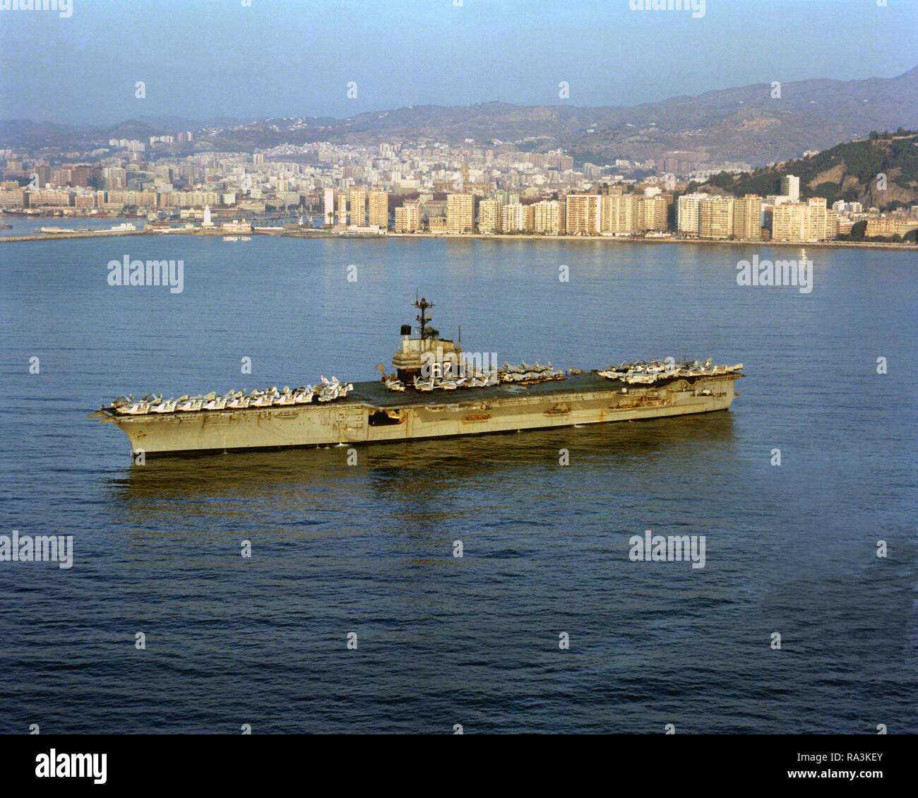 1979 - Una porta vista di prua della portaerei USS INDIPENDENZA (CV-62) ancorati nel porto. Foto Stock