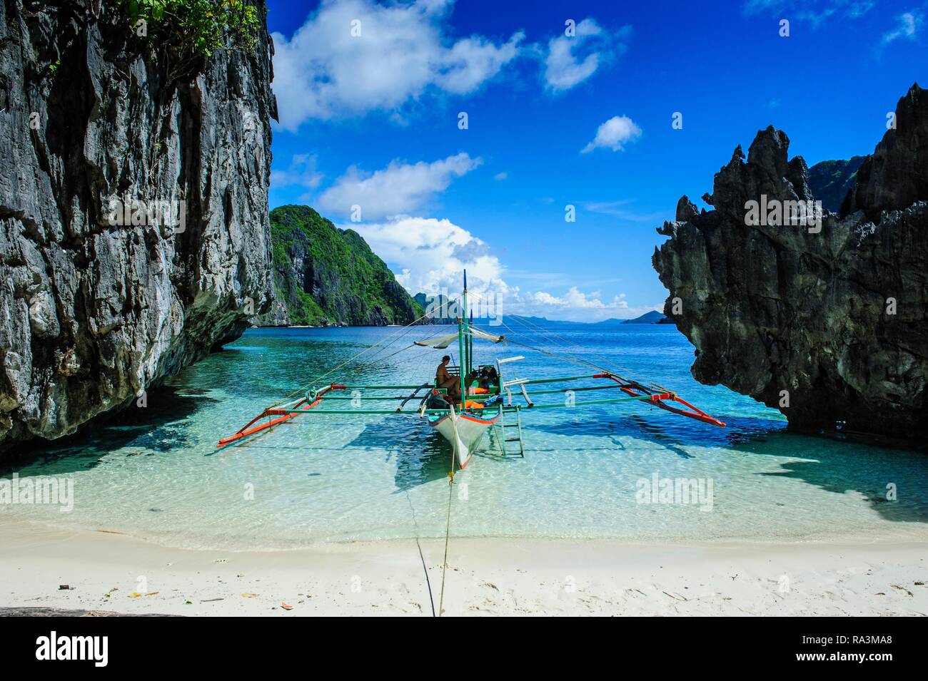 Outrigger barca su un po' di spiaggia di sabbia bianca e acqua cristallina nell'arcipelago Bacuit, PALAWAN FILIPPINE Foto Stock