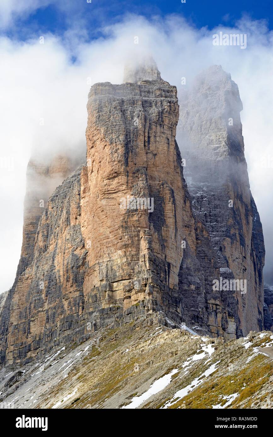 Tre Cime di Lavaredo sud pareti ricoperte da profonde nuvole, cielo blu, Dolomiti di Sesto, provincia Sud Tirolo, Alto Adige, Italia Foto Stock