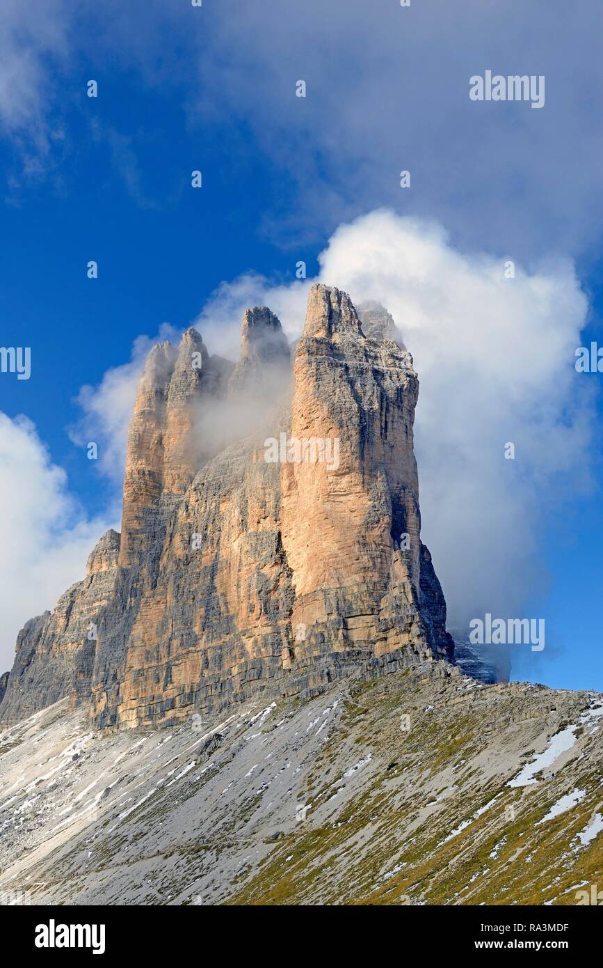 Tre Cime di Lavaredo sud pareti ricoperte da profonde nuvole, cielo blu, Dolomiti di Sesto, provincia Sud Tirolo, Alto Adige, Italia Foto Stock