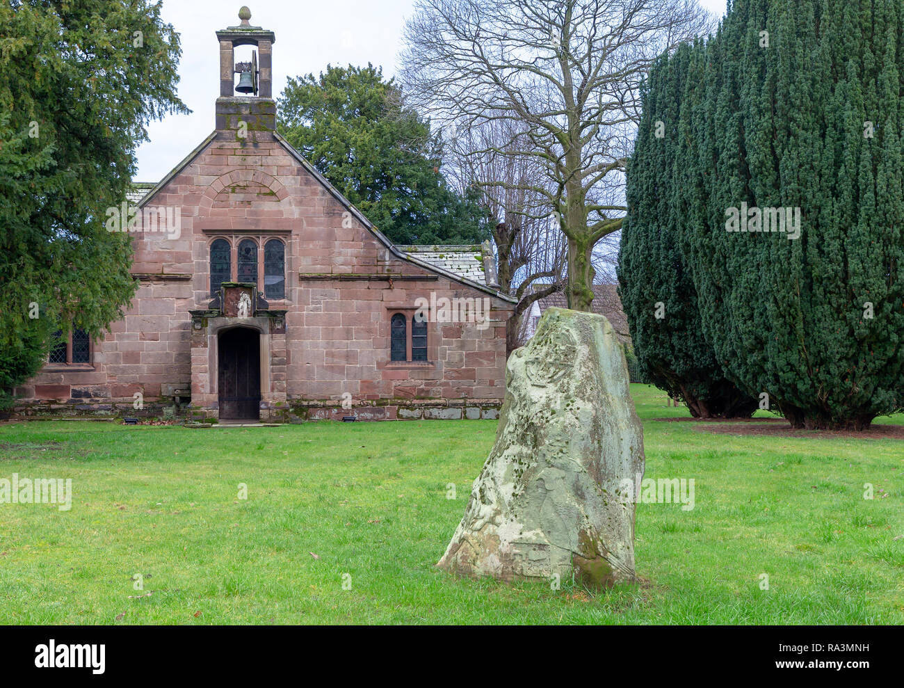 Sportello anteriore della cappella della Beata Vergine Maria, Alta Legh, Cheshire, Inghilterra, Regno Unito con il Millenium pietra in primo piano Foto Stock