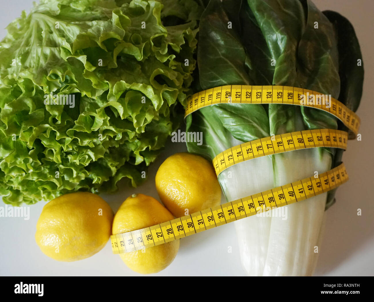 Nastro di misurazione su verdure e limone. Fresco e cibi sani per la disintossicazione, dieta e perdita di peso Foto Stock