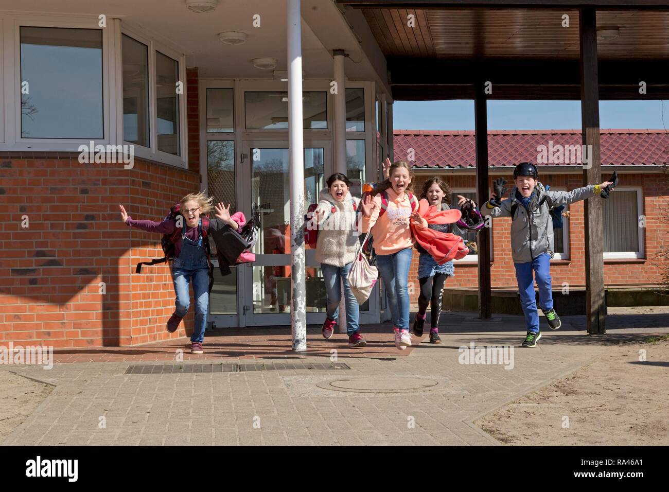 Gli studenti dopo la scuola, inizio di vacacions, in esecuzione al di fuori della scuola, scuola primaria, Bassa Sassonia, Germania Foto Stock