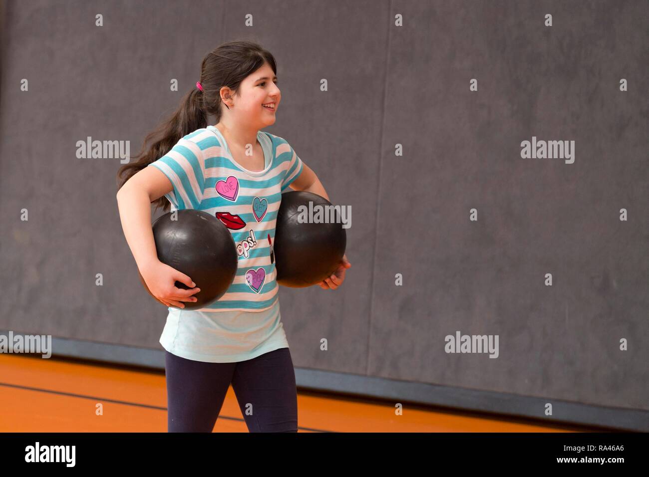 Schoolgirl giocare palla in palestra, educazione fisica, scuola primaria, Bassa Sassonia, Germania Foto Stock