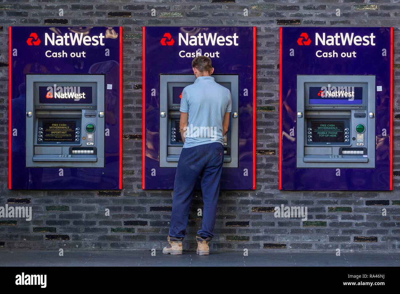 Uomo al cash dispenser di Natwest Bank di Londra, Gran Bretagna Foto Stock