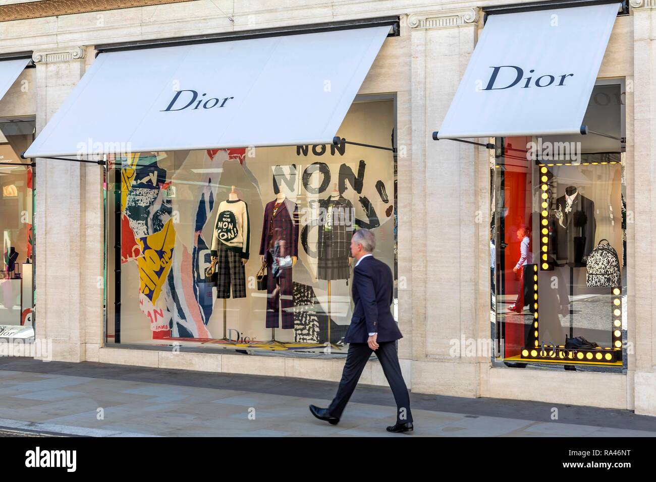 Passante nella parte anteriore del negozio finestra, fashion shop Dior, London, Regno Unito Foto Stock