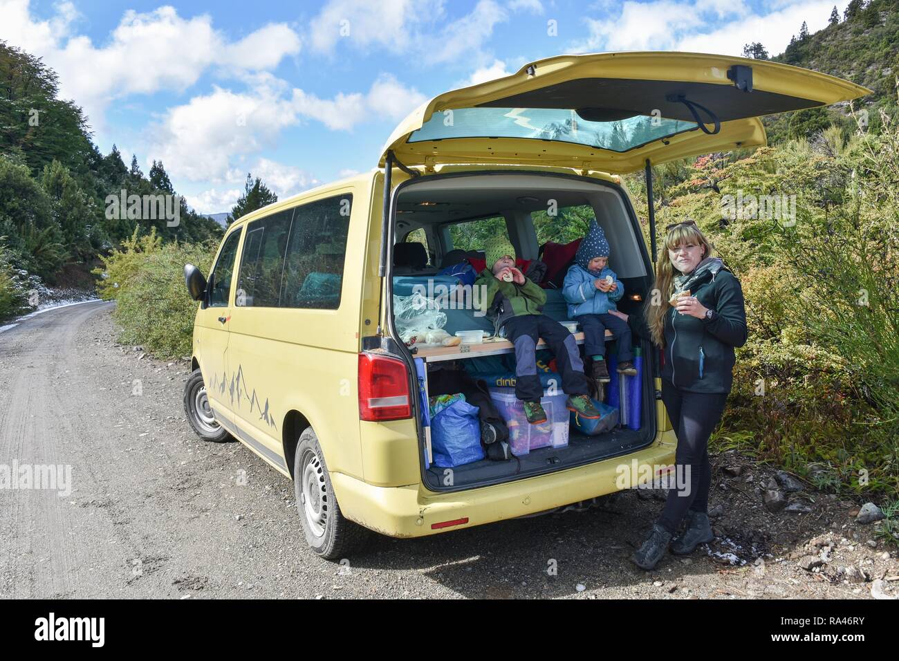 Famiglia su un viaggio, avente uno spuntino presso il campeggio giallo bus, Ruta 40, Patagonia, Argentina Foto Stock