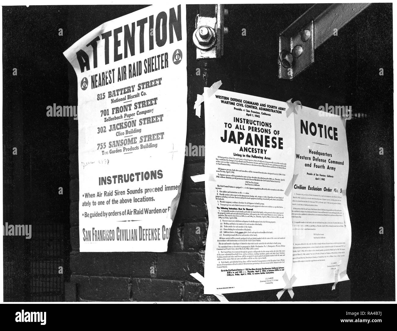 San Francisco, California. Su un muro di mattoni accanto a Air Raid Shelter poster, ordini di esclusione sono state pubblicate in un primo momento e strade anteriore dirigere il distacco delle persone di ascendenza giapponese dal primo San Francisco sezione per essere influenzata da evacuazione. Il provvedimento è stato emesso il 1 aprile 1942, dal tenente generale J.L. DeWitt e evacuazione diretta da questa sezione da mezzogiorno del 7 aprile 1942. (4/11/1942) Foto Stock