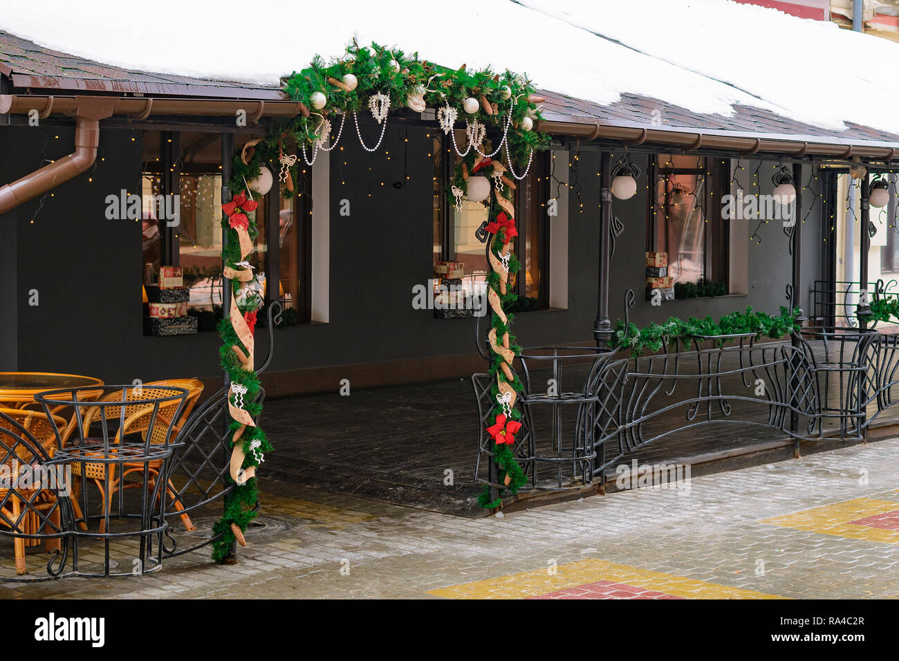 L'ingresso al bar è decorato con rami di abeti e addobbi per l'albero di Natale in inverno sulla strada in città. Foto Stock