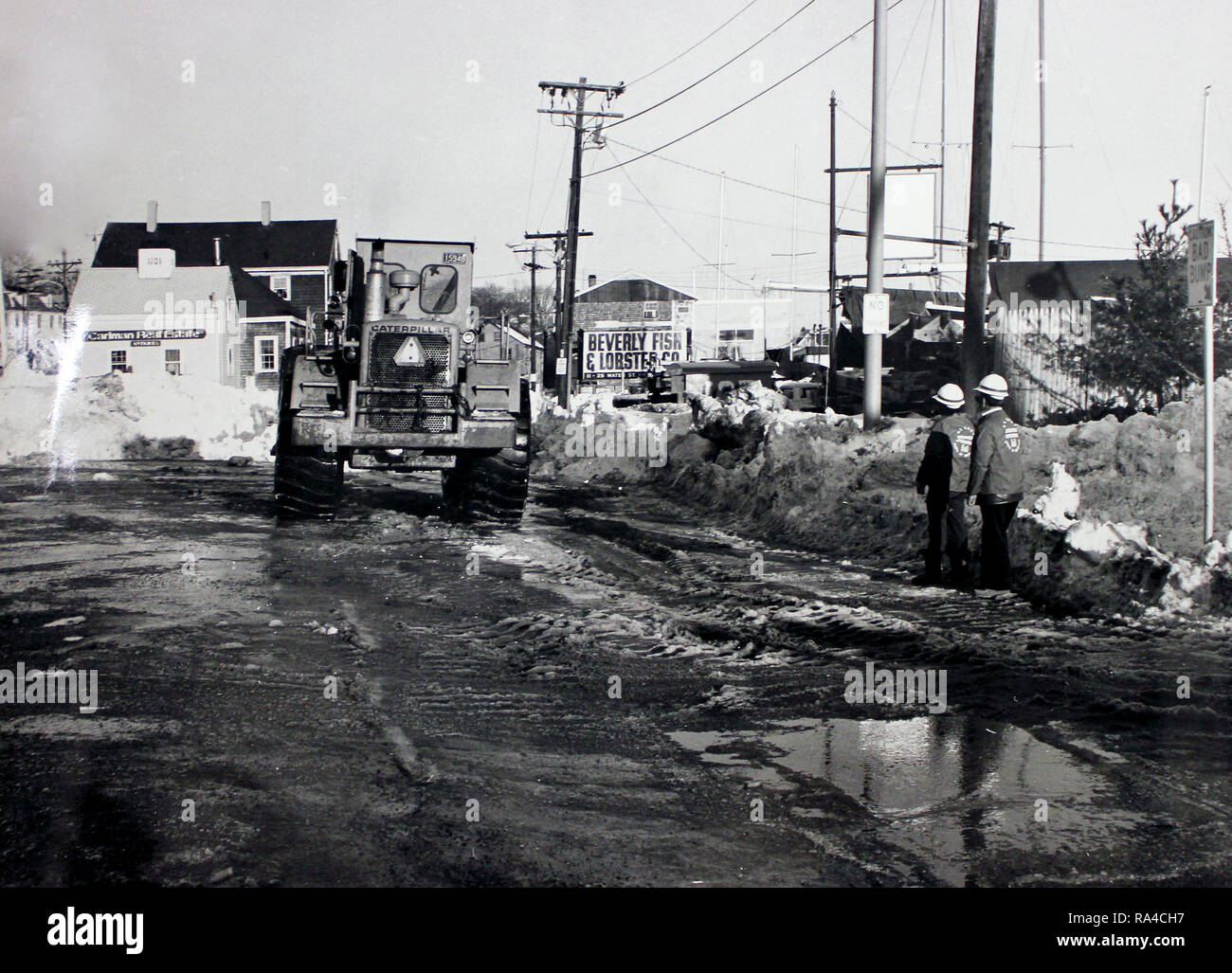 Questa fotografia mostra rimozione neve equipaggi al lavoro dopo il 1978 blizzard che ha colpito il nord-est degli Stati Uniti. Questa fotografia mostra la vicinanza del Beverly Pesce & Lobster Azienda e Carlman Real Estate all'intersezione di acqua, anteriore e Cabot strade di Beverly, Massachusetts. Foto Stock