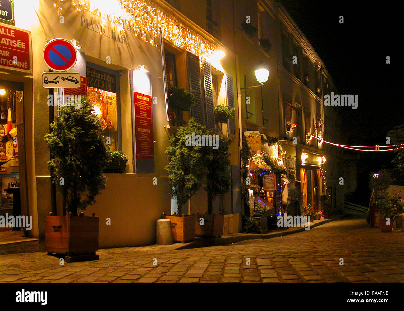 Rue Poulbot, Montmartre, Paris, Francia la notte: ciottoli e caffè Foto Stock